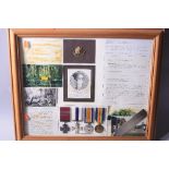 A LARGE GLAZED FRAME CONTAINING MEDALS, photos and ephemera relating to a 2nd Lt J Harrison. East