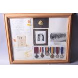 A LARGE GLAZED FRAME CONTAINING MEDALS, photos and ephemera relating to a Pte John Cunningham VC (