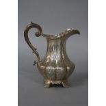 AN EARLY VICTORIAN SILVER MILK JUG, pie crust rim, 'S' scroll handle, lobed baluster body with