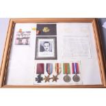 A LARGE GLAZED FRAME CONTAINING MEDALS, photos and ephemera relating to a Pte Eric Anderson VC (