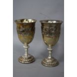 A PAIR OF VICTORIAN SILVER CUPS, each applied with a silver band of classical male figures with