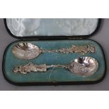 A CASED PAIR OF 19TH CENTURY CONTINENTAL SILVER SPOONS, cast with a male and female figure to the