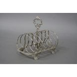 A GEORGE III SILVER SEVEN BAR TOAST RACK, of rectangular outline, foliate cast central carrying