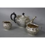 AN EDWARDIAN SILVER THREE PIECE BACHELORS TEA SERVICE, of oval form, foliate embossed decoration,