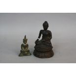 A CAST BRONZE FIGURE OF A SEATED BUDDHA, in a pose of Calling The Earth to Witness, on a circular