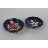 TWO SMALL MOORCROFT FOOTED BOWLS, both dark blue ground, one with Columbine design, diameter