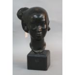 AN EARLY 20TH CENTURY ORIENTAL BRONZE HEAD, of a female with her hair tied up in a bun, black