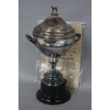 AN ELIZABETH II TWIN HANDLED TROPHY CUP AND COVER, greyhound finial to domed circular cover, the cup