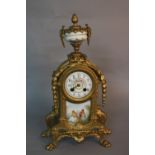 A MID 19TH CENTURY STYLE GILT METAL MANTEL CLOCK, pineapple finial on a porcelain urn (s.d.), on