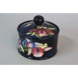 A MOORCROFT ORCHID PATTERN CIRCULAR BOWL AND COVER, dark blue mottled ground, impressed marks