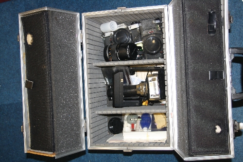 AN ALUMINIUM CASE, containing an Olympus OM10, an OM40 Program, an Olympus 28mm 1:2.8 lens, a
