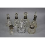 FIVE EARLY 20TH CENTURY CUT GLASS SCENT BOTTLES WITH HALLMARKED SILVER COLLARS, another jar with