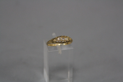 AN EARLY 20TH CENTURY DIAMOND HALF HOOP RING, open work sides and scroll design shoulders, five