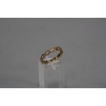 A MID 20TH CENTURY SYNTHETIC WHITE SPINEL FULL ETERNITY RING, ring size Q, stamped 9ct,