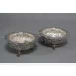 A PAIR OF INDIAN WHITE METAL CIRCULAR DISHES, pierced an d embossed wavy rims, the bodies of