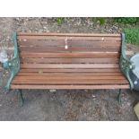 A HARDWOOD SLATTED GARDEN BENCH, with painted cast iron ends, approximate length 126cm