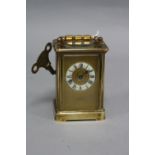 A LATE VICTORIAN BRASS CASED CARRIAGE CLOCK, circular chapter ring with Roman numerals, the gilt