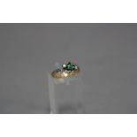 A MID-LATE 20TH CENTURY EMERALD AND DIAMOND THREE STONE CROSS OVER DESIGN RING, one square cut