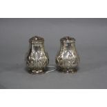 A PAIR OF VICTORIAN SILVER CASTORS OR PEPPERETTES, of baluster form, covers (a.f), engraved crest