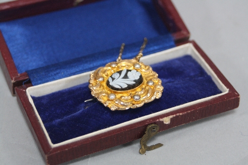A VICTORIAN HIGH CARAT MOURNING BROOCH, set with a carved hardstone