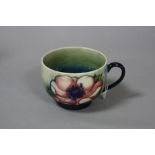 A MOORCROFT POTTERY CUP, 'Anemone' pattern, paper label to base