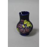 A SMALL MOORCROFT POTTERY VASE, 'Clematis' pattern on blue ground, paper label to base, 'Potters