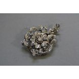 AN EARLY 20TH CENTURY DIAMOND BROOCH PENDANT, a fancy floral and scroll open work design, centring