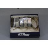 A SET OF SIX GEORGE V SILVER LOZENGE SHAPED NAPKIN RINGS, engine turned decoration, blind