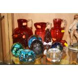 A GROUP OF GLASSWARES, to include cranberry coloured jugs and salt (5) and seven paperweights,
