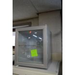 A SMALL GLASS FRONTED BOTTLE FRIDGE