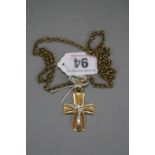 A 9CT CRUCIFIX ON A YELLOW METAL CHAIN