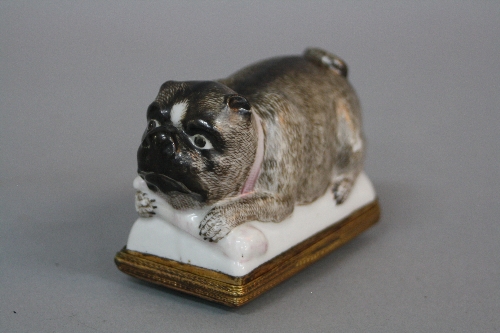 A 19TH CENTURY CONTINENTAL ENAMEL AND PORCELAIN SNUFF BOX, of recumbant Pug form, with pink collar