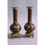 A PAIR OF LATE 19TH CENTURY CHINESE BRONZE ONION SHAPED VASES, gilt metal rims, above birds, flowers