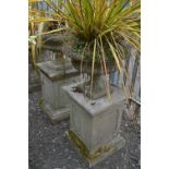 A PAIR OF LARGE COMPANA STYLE PRECAST URNS, on square columns, approximate total height 113cm x