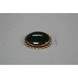 A MID TO LATE 20TH CENTURY NEPHRITE JADE BROOCH, oval cabochon measuring approximately 24mm x