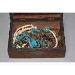 A WOODEN BOX OF MIXED ETHNIC JEWELLERY