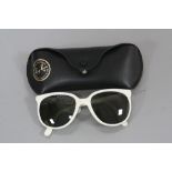 A PAIR OF CASED RAY BAN SUNGLASSES, the frames in white plastic marked to the arms Ray.Ban and Cats,