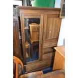 A WALNUT COMPACTUM MIRROR DOOR WARDROBE, oposing a single door, three short drawers above a single