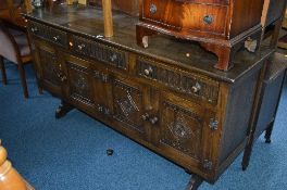 A CARVED OAK SIDEBOARD, with three drawers, approximate size width 197cm x depth 46cm x height 87cm