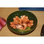 A SMALL MOORCROFT POTTERY FOOTED TRINKET BOWL, 'Hibiscus' pattern on green ground, impressed marks