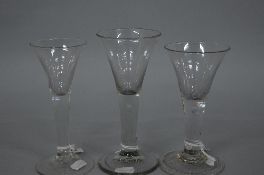 A MID 18TH CENTURY WINE GLASS, funnel shaped bowl, plain stem, height approximately 17cm, together