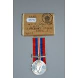 A BOXED WWII WAR MEDAL, with ribbon, box addressed to Mrs S Gelston, Flat 5, 11, Palmeira Sq, Hove