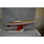 A WOODEN POND YACHT, in need of minor restoration, length approximately 130cm x width 30cm, on a