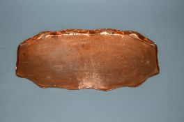 AN ARTS & CRAFTS STYLE OVAL COPPER TRAY, wavy edge surrounding a stamped design of two fish,