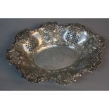A LATE VICTORIAN SILVER DISH, of oval form, wavy edge embossed with shells and scrolls above