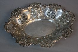 A LATE VICTORIAN SILVER DISH, of oval form, wavy edge embossed with shells and scrolls above
