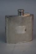 AN ELIZABETH II SILVER HIP FLASK, of concave form, engine turned decoration with vacant