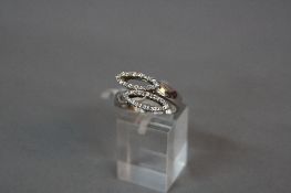 A MODERN 18CT WHITE GOLD DIAMOND DRESS RING, two crossover diamond set marquise shapes, estimated
