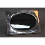 A GEORGE V RECTANGULAR SILVER PHOTOGRAPH FRAME, with oval glazed opening, bobbin moulded borders,