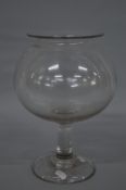 A MID 19TH CENTURY GLASS LEECH JAR, with turned over plain rim, globular bowl, plain stem and deep